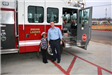Girl and Fireman Standing in Front of a Fire Truck