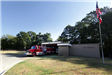 Fire Truck Parked at a Station with an American Flag Pole in the Foreground