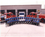 Two Rows of Firefighters in a Group Photo in Front of a Fire  Station