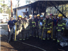 Firefighters Standing in Front of a Burned Structure