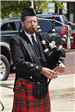 Man Playing a Bagpipe in Traditional Clothing